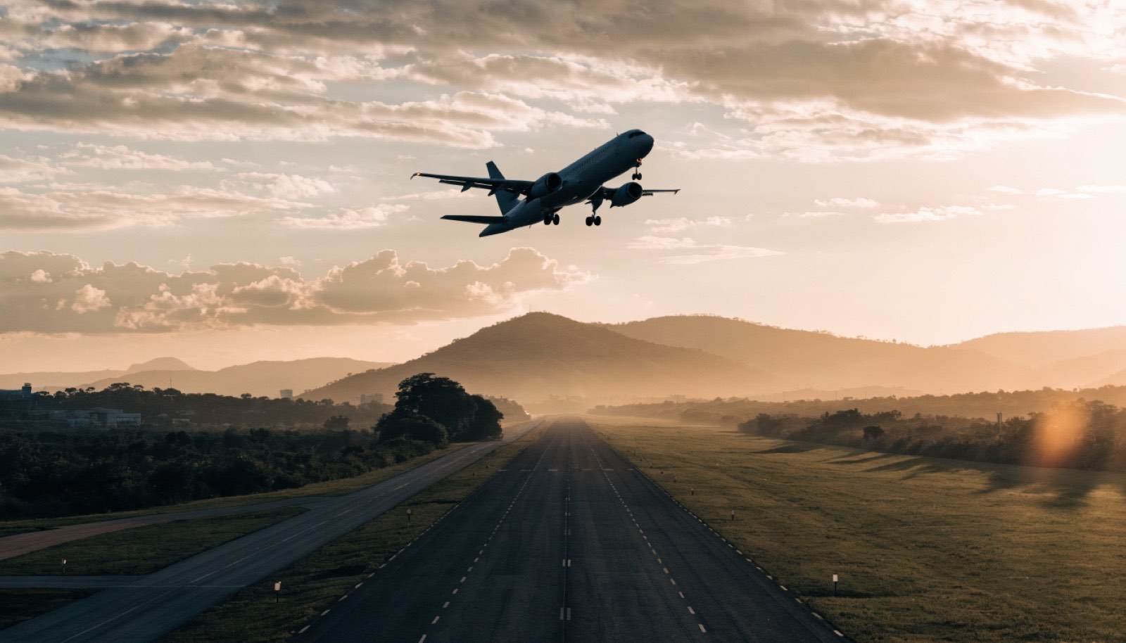 Avião decolando de aeroporto ao entardecer