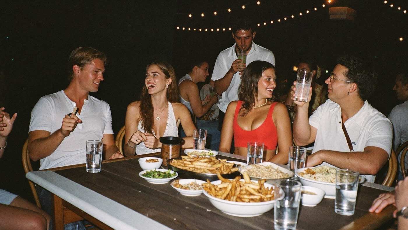 Amigos reunidos em mesa de bar à noite