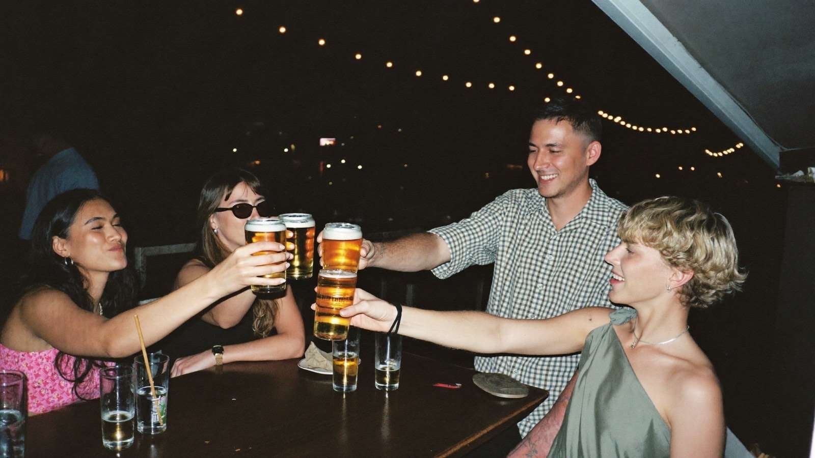 Pessoas brindando com bebidas em bar