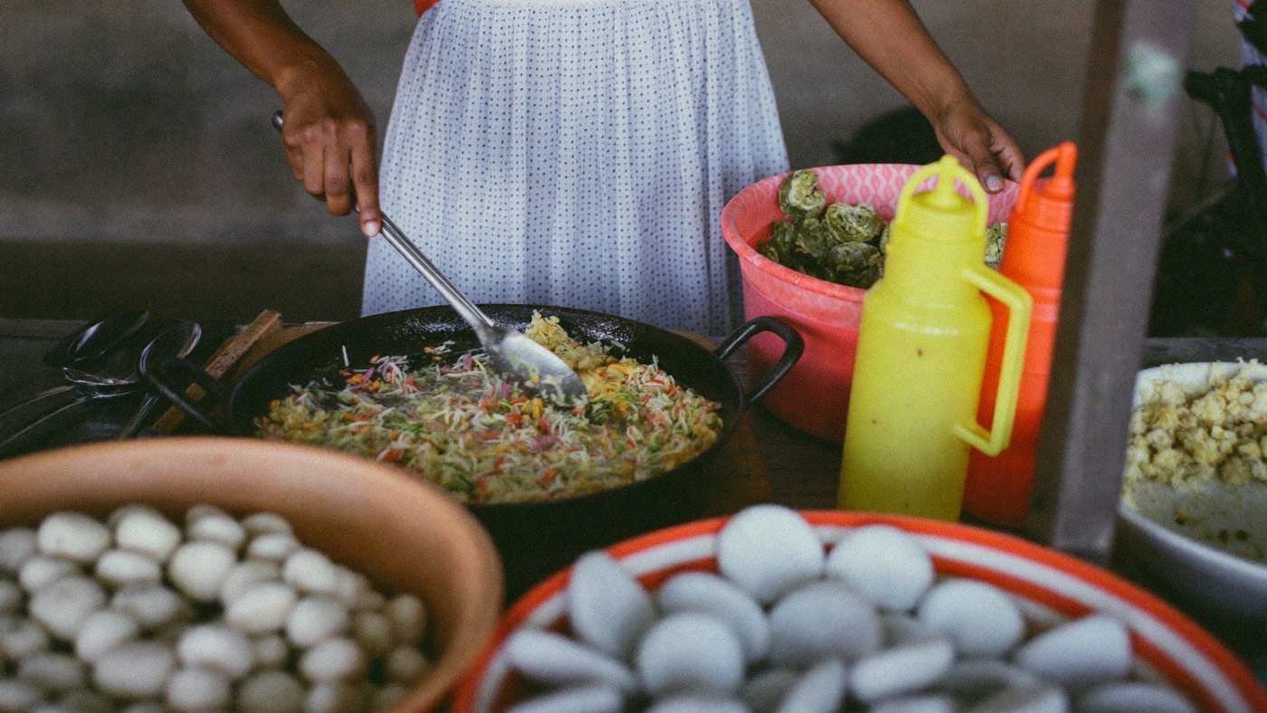 Baiana preparando acarajé em tabuleiro tradicional