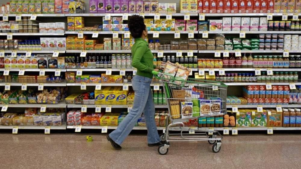Pessoa fazendo compras em supermercado conferindo preços