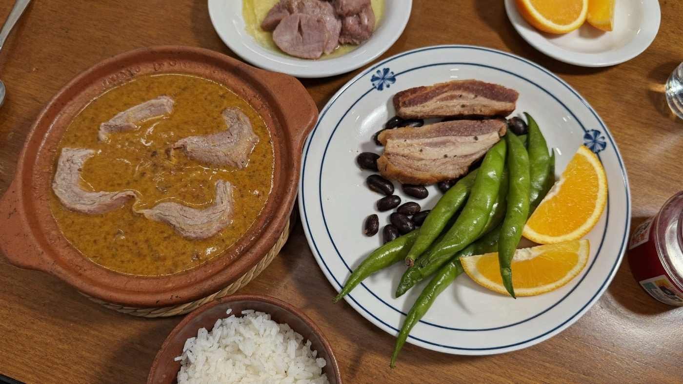 Prato de feijoada com farofa, couve e laranja em restaurante tradicional