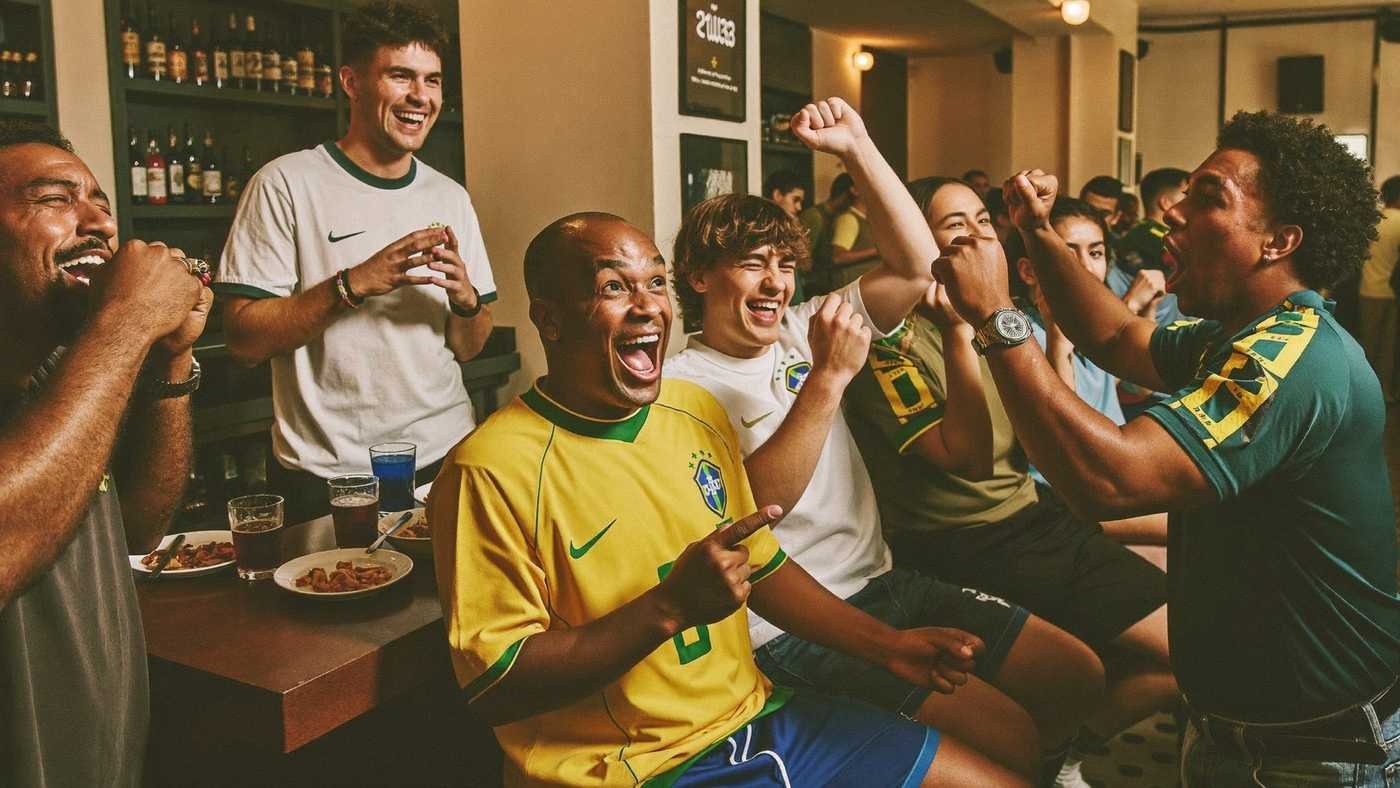 Torcedores brasileiros comemorando gol em bar, com camisa da seleção
