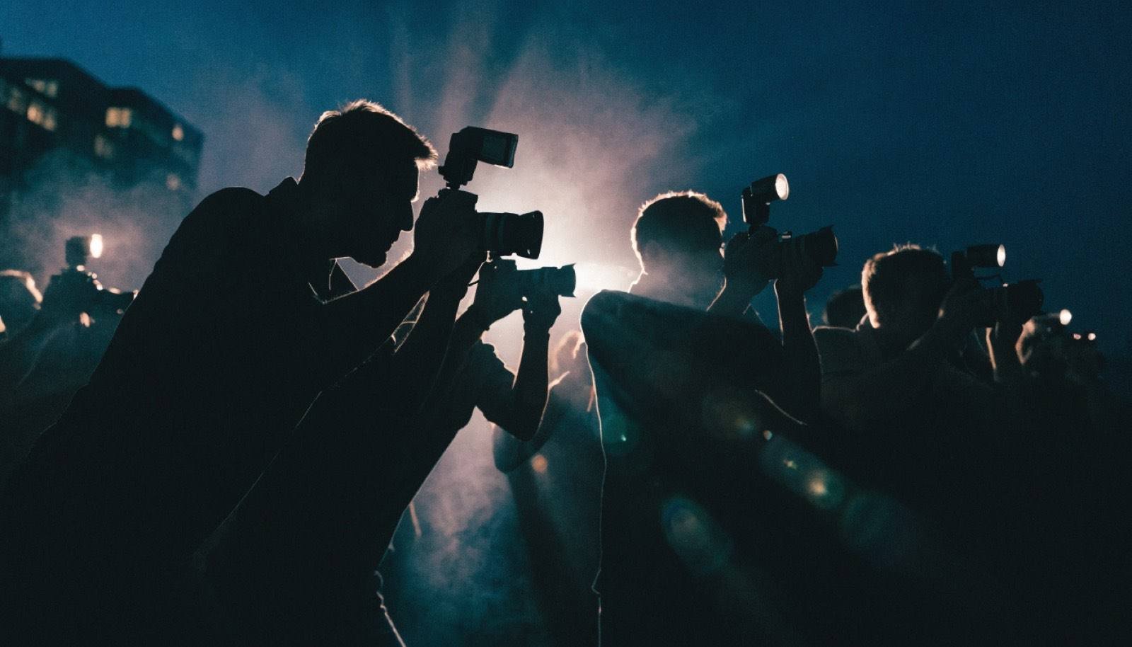 Fotógrafos e cinegrafistas com câmeras em cobertura jornalística