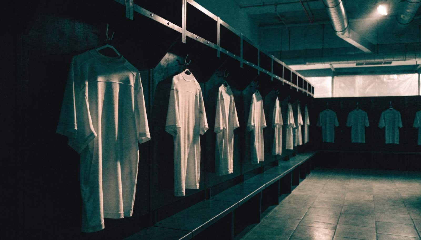 Vestiário de futebol com uniformes pendurados