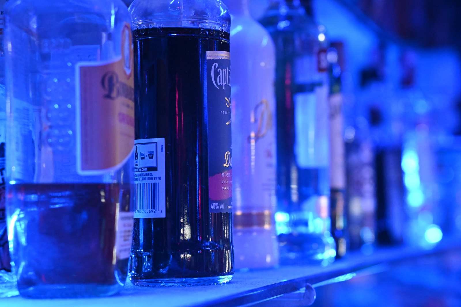Garrafas de bebidas alinhadas em prateleira de bar com luz azul (Foto: PattayaPatrol/Wikimedia Commons, CC BY-SA 4.0)
