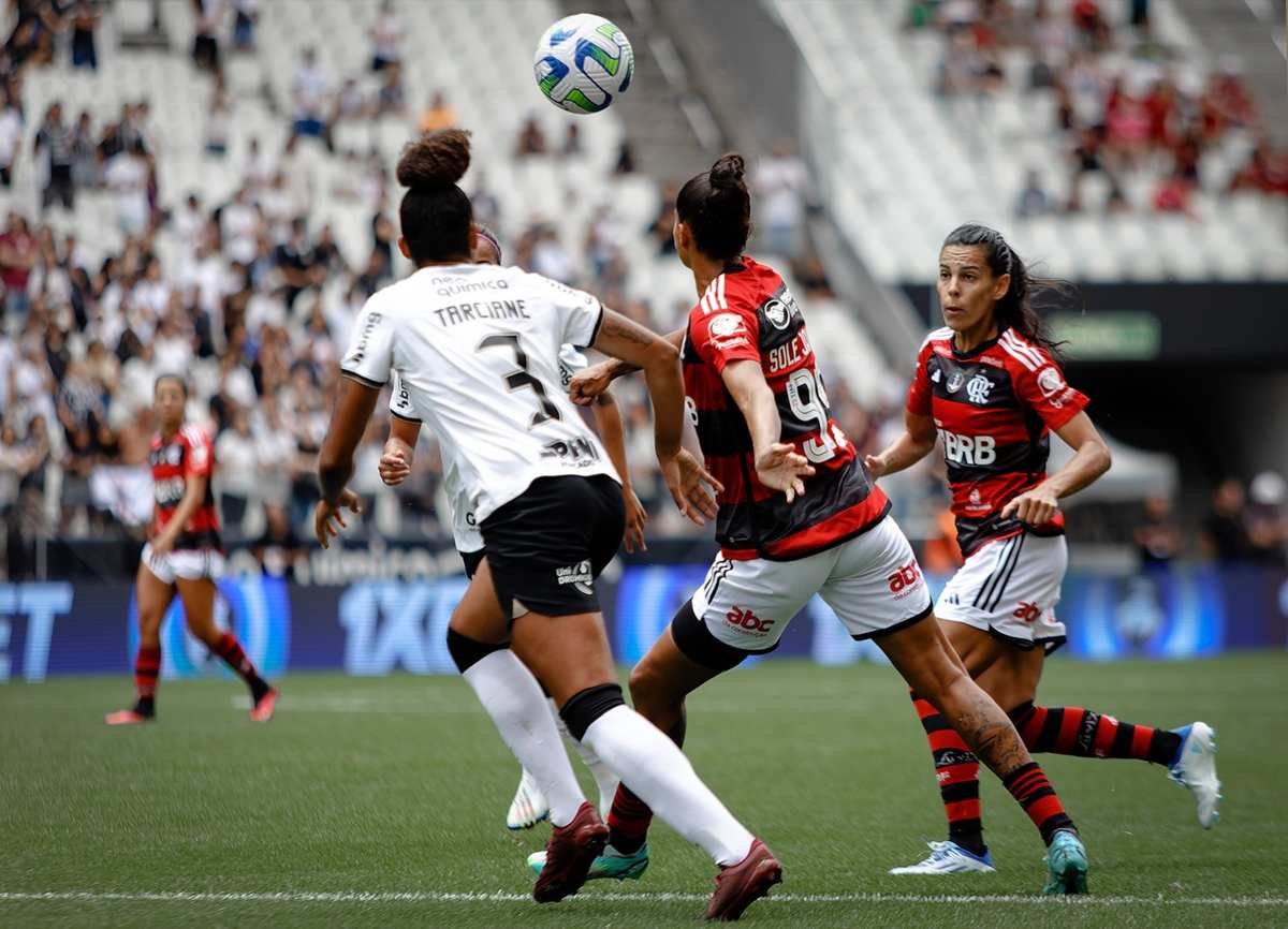 Jogadora do Corinthians disputa bola em partida no uniforme branco e preto do clube