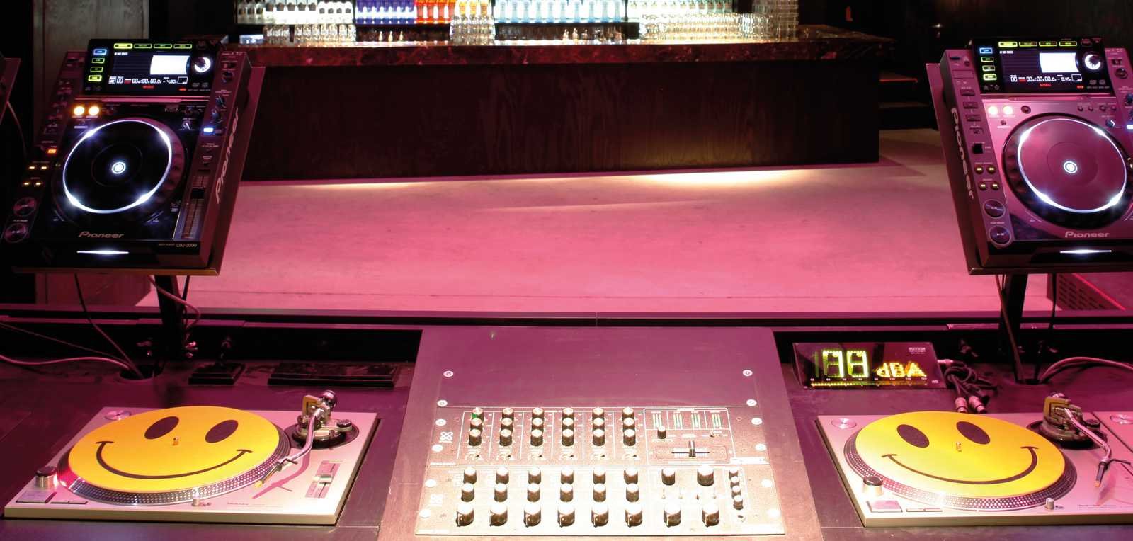 Cabine de DJ com toca-discos e mixer em pista de casa noturna iluminada (Foto: Arnold Jaeger Werner/Wikimedia Commons, CC BY 2.0)