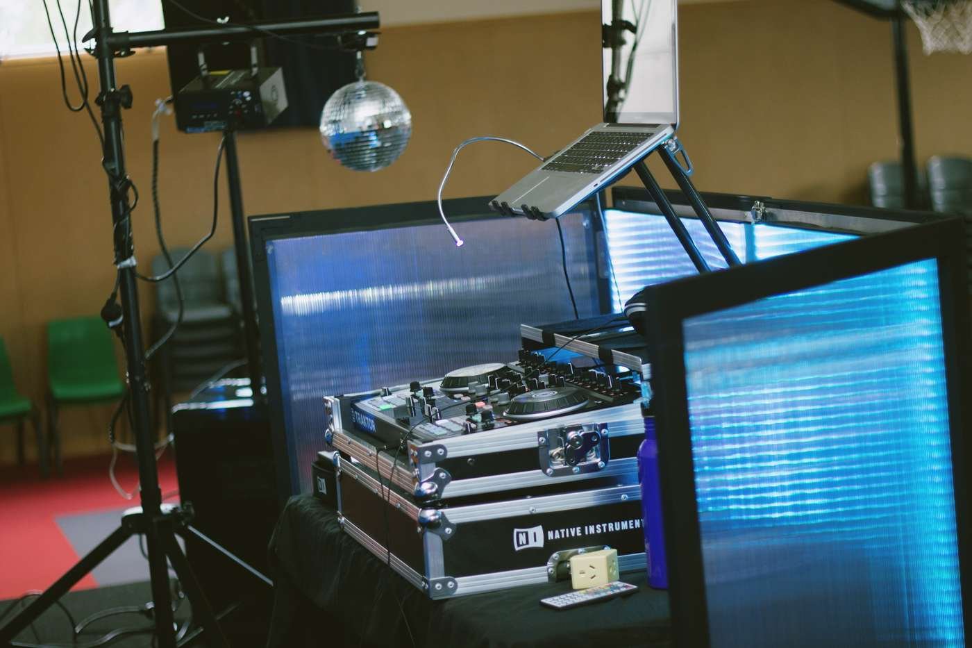 Equipamento de DJ com controladora Traktor sob luz azul e bola de espelhos ao fundo (Foto: Nikkole Lulu/Wikimedia Commons, CC0)